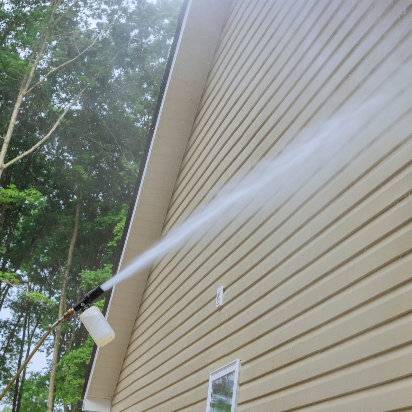 Pro Window Cleaning Calgary washing siding houses by using high pressure nozzles spray water soap cleaner